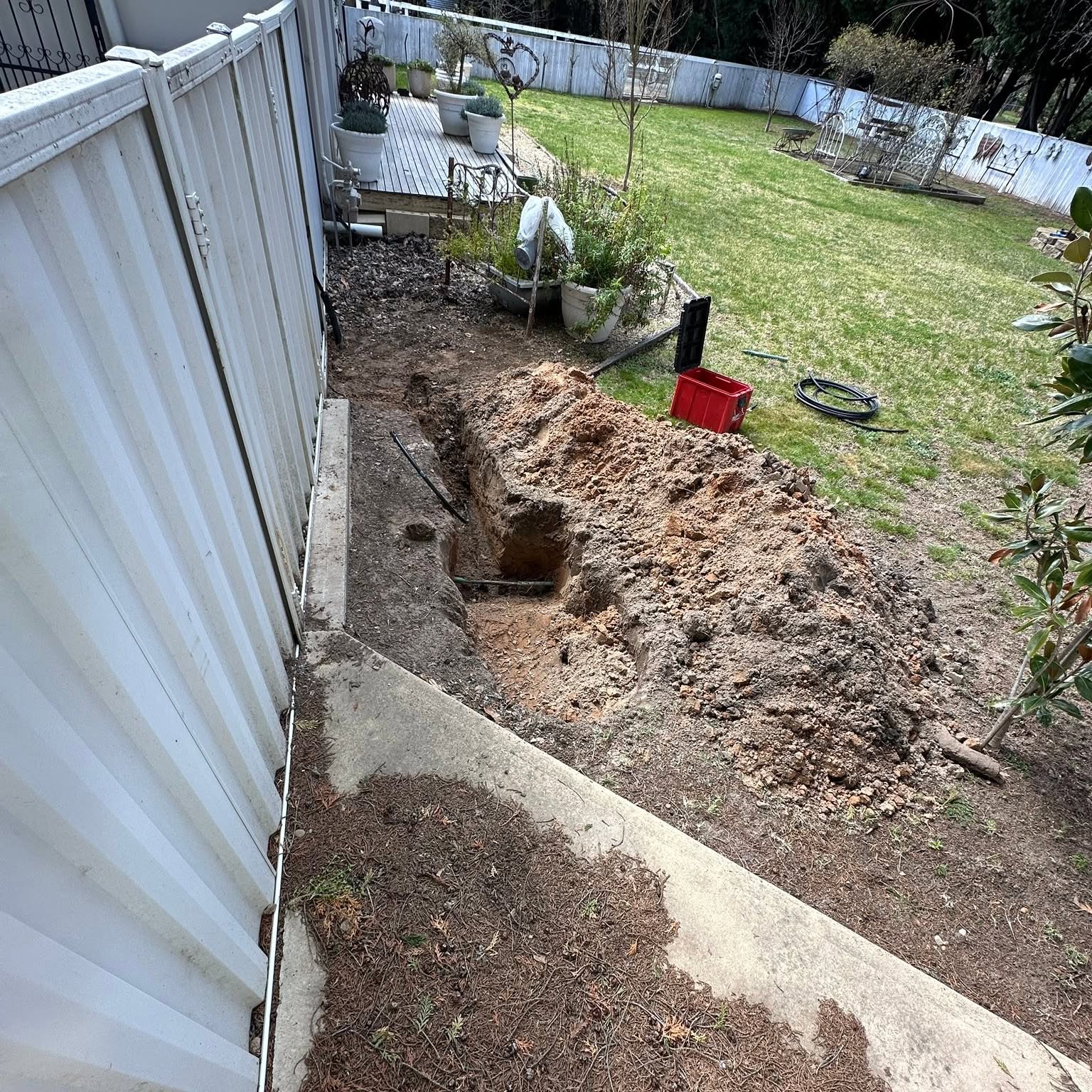 Trench dug along a fence line at a Bungendore property, spoil stacked clear of the lawn