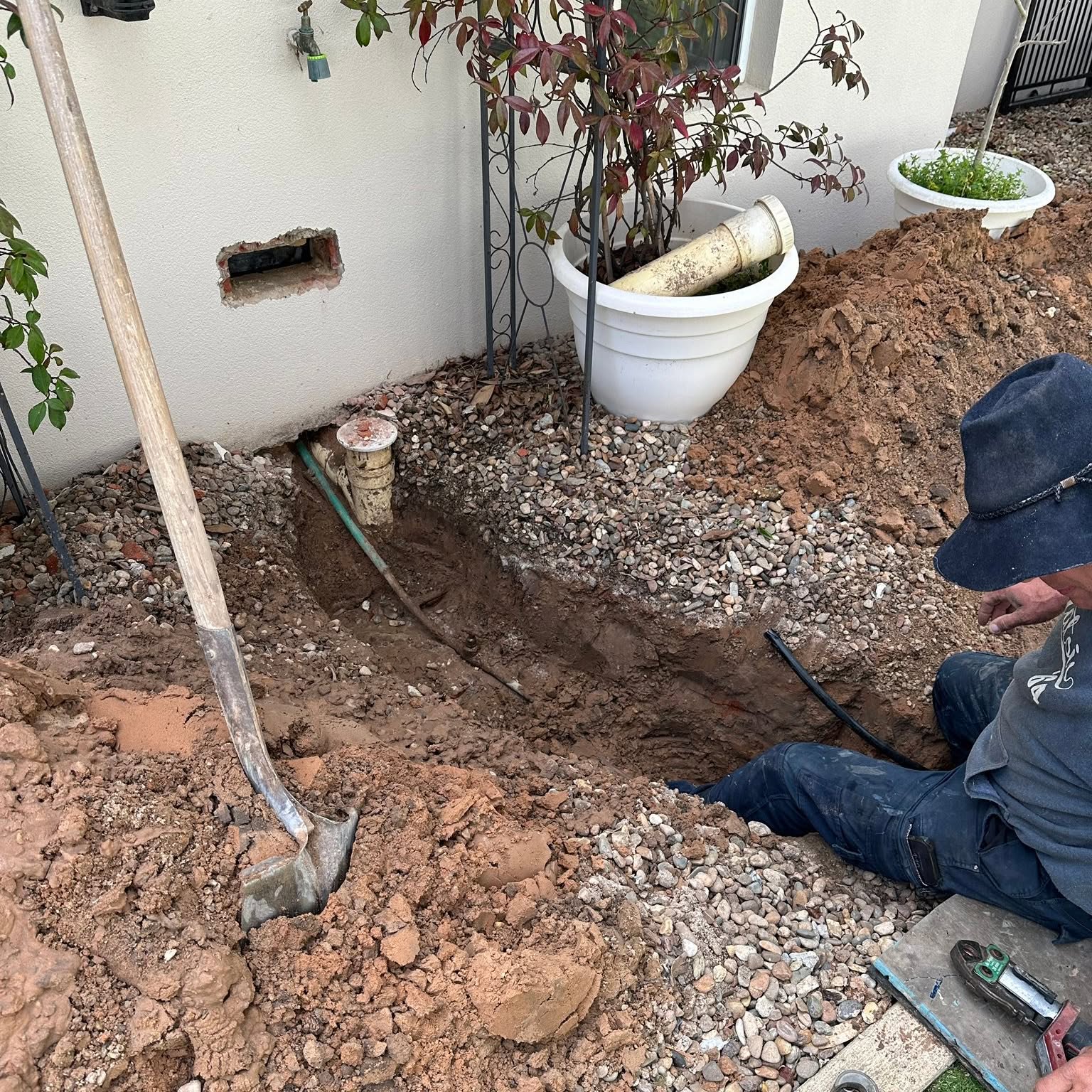 Exposed water meter riser at the wall of a house partway through the repair